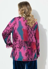 Blusa leggera e colorata con design a stampa serpente rosa e blu, maniche lunghe con polsini arricciati e vestibilità comoda.