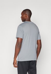 Grå kortermet t-skjorte med klassisk rund hals, laget av et glatt stoff, med avslappet passform og minimalistisk design.