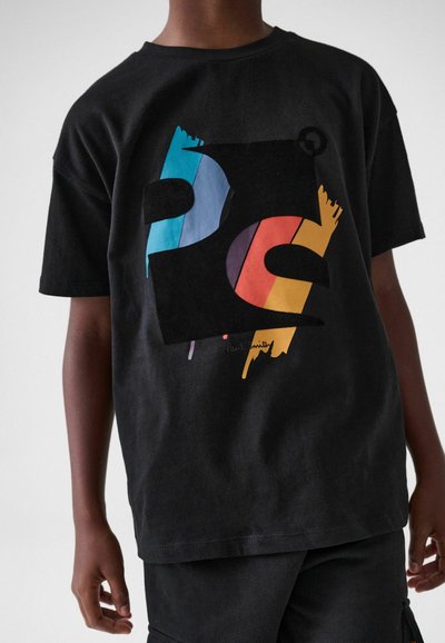 Mustan puuvillaisen t-paidan, jossa on monivärinen abstrakti graafinen muotoilu, jossa on sinisiä, punaisia, keltaisia ja mustia elementtejä. T-paita on muotoiltu rentoon istuvuuteen.