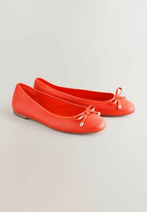 Coral leather ballet flats with a rounded toe, flat sole, and two small bows at the front adorned with metallic accents.