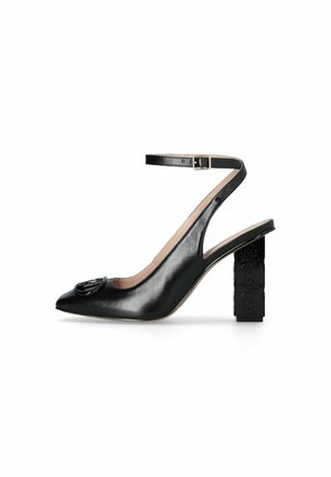 Pump slingback in pelle nera con tacco a blocco quadrato, cinturino alla caviglia con fibbia, punta affusolata e dettaglio logo impresso sulla punta.
