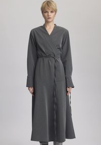 Rochie gri cu mâneci lungi, dungi verticale, talie cu curea și fustă fluidă; realizată dintr-un material texturat moale.
