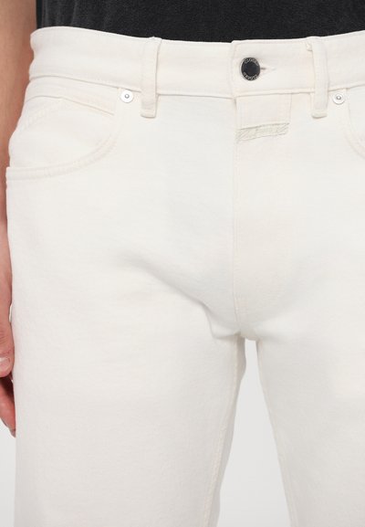 Vita denimjeans med rak bendesign. Funktioner inkluderar en knappstängning fram, bältesloops och subtila sömmar på fickorna.