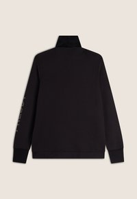 Pullover nero con collo alto, maniche lunghe e polsini a coste. Presenta un dettaglio testuale sulla manica sinistra in un colore contrastante. Texture liscia.