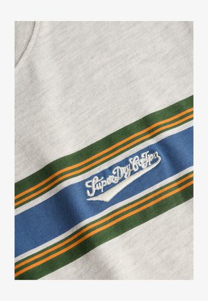 Tissu gris clair avec des rayures horizontales vertes, orange et bleues avec le texte brodé blanc "SuperDry & Sons".