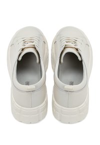 Witte leren sneakers met een stevige zool, textuur op het oppervlak en vetersluiting. Bevat subtiele branding op de binnenzool en de achterste tab.