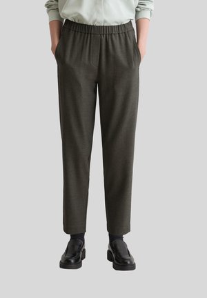 Grijze taps toelopende broek van gestructureerde stof, met een elastische tailleband en zijzakken, in combinatie met zwarte schoenen.