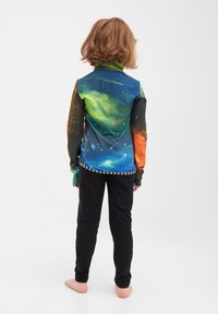 Langærmet skjorte med et galaksedesign i grøn, blå, orange og sort, parret med sorte leggings. Blødt stof, slank pasform.