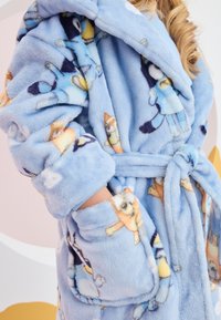 Accappatoio in pile azzurro chiaro con motivo di animali da cartone animato, con cintura, ampie tasche e tessuto morbido. Adatto per calore e comfort.