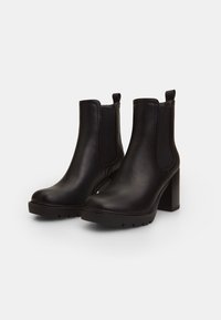 Botine negre din piele cu panou elastic pe laturi și toc texturat; vârful rotund și talpa cu profil pentru aderență.