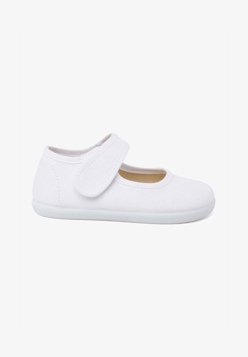 Zapatilla de lona blanca con un diseño de Mary Jane, que presenta una correa de velcro, puntera redondeada y suela de goma plana y texturizada.
