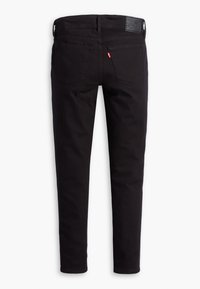 Mustad teksapüksid, millel on istuv lõige. Omavad kahte tagataskut, nahast plaastrit ja ühtlast värvi kogu kangal.