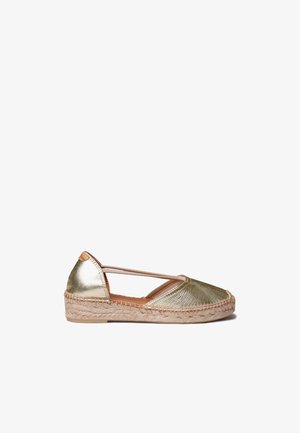 Πλατφόρμα espadrille με χρυσό δερμάτινο επάνω μέρος, πλεγμένη σόλα από γιούτα και ελαστικό λουράκι που περνάει διαγωνίως από πάνω, εμφαινόμενο από πλάγια όψη σε λευκό φόντο.