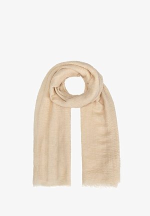 Beżowy szal o teksturowanym, tkanym wykończeniu, wykonany z miękkiego, lekkiego materiału, z frędzlami na krawędziach, zwinięty w luźną pętlę.