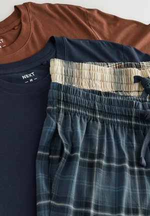 Három ruhadarab: egy barna póló, egy sötétkék póló és kockás otthoni nadrág kékekkel, krém színekkel és feketével, rugalmas derékkal.