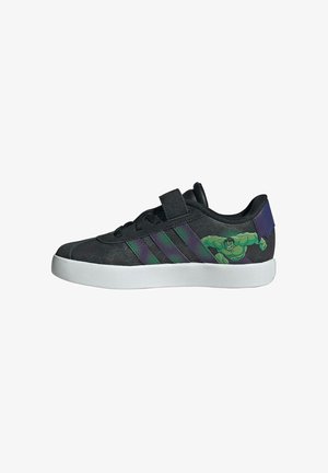Scarpa da ginnastica nera con suola bianca, strisce verdi e viola, chiusura in velcro e grafica di Hulk sul lato che tiene un oggetto viola strappato.