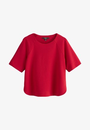 Raudona trumpa rankovėmis bluzė su apvalia iškirpte ir paprastu, laisvu siluetu, pateikta baltoje fone.