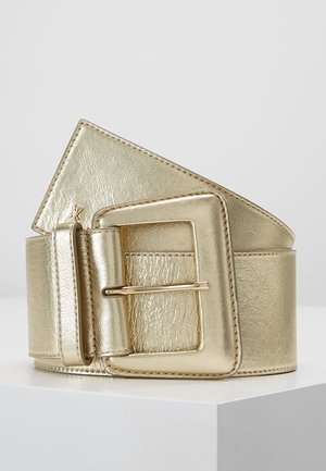 Brede metallic gouden leren riem met een grote vierkante gesp en gestikte randen, opgerold tentoongesteld op een witte ondergrond.