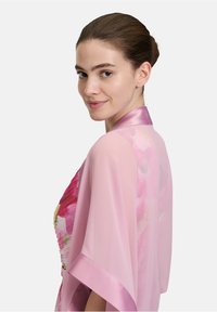 Zijden kimono in lichtroze met een bloemmotief, voorzien van brede mouwen en een satijnen kraag. Zachte textuur en vloeiende uitstraling.