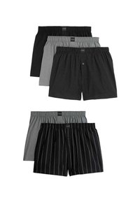 Cinco pares de calzoncillos de diferentes colores: negro sólido, gris sólido, negro con puntos, cuadro gris y negro con rayas blancas. Cinturas elásticas.