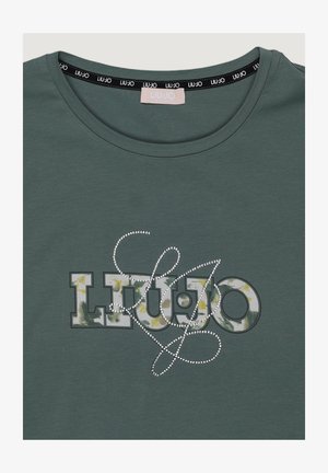 Maglietta verde con scollo rotondo, con lettere "Liu Jo" decorate da un motivo floreale e una scritta decorativa sovrapposta in strass argentati sul davanti.