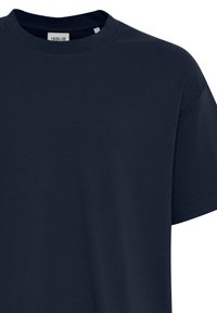 Tricou din bumbac de culoare bleu marin, cu gât rotund, mâneci scurte și o textură netedă, având o etichetă mică pe gât.