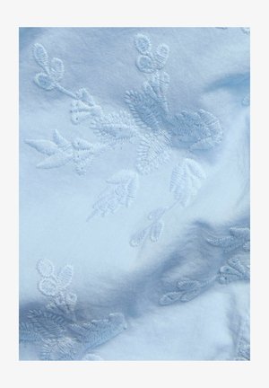 Ljusblått tyg med intrikata vita blommönster, med delikata blad- och blommotivar, en mjuk textur och ett mjukt utseende.