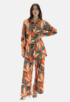 Oranje bloemen loungewear set met een lange mouwen overhemd met knopen en wijde broek met een groot bladerenpatroon in blauwe en beige tinten.