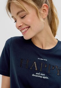 T-shirt en coton bleu marine avec un texte brodé : "il est temps d'être HEUREUX et de recommencer à rêver" dans une police décorative.