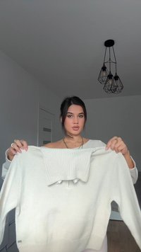 Kremowy sweter dz Dzianinowy o żeberkowanej fakturze, z krótszym krojem i detalem w postaci sznureczka. Materiał wydaje się miękki i lekki.