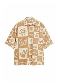 Kortærmet skjorte med et beige og cremefarvet abstrakt mønster, der indeholder forskellige grafiske elementer, herunder sole og håndaftryk.
