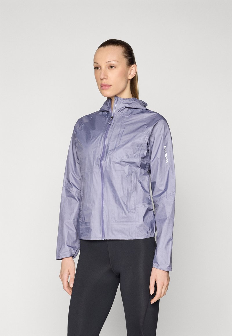 Lightweight, hooded jacket in soft lavender color, made of water-resistant fabric with a smooth texture. Features a front zipper and two side pockets.