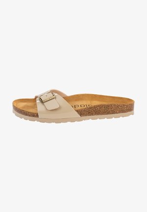 Sandalia tipo slide beige con plantilla de corcho, una sola tira ancha con hebilla dorada, y suela texturizada.