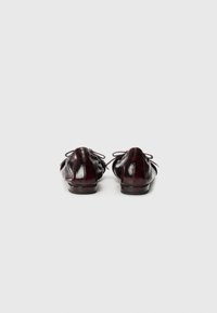 Chaussures en cuir verni bourgogne au design simple, à bout rond et avec des lacets décoratifs. Talon bas et détail texturé à l'arrière. Convient pour un style décontracté.