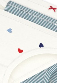 Βαμβακερά εσώρουχα σε λευκό χρώμα με μικρά μπλε και κόκκινα σχέδια καρδιάς. Διαθέτουν ριγωτή μπλε ζώνη στη μέση με διακοσμητικό περίγραμμα και αντίθετες κορδέλες.