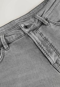 Blugi din denim gri cu talie, închidere cu nasture și detalii cusute. Prezintă o textură netedă și un model ușor decolorat.