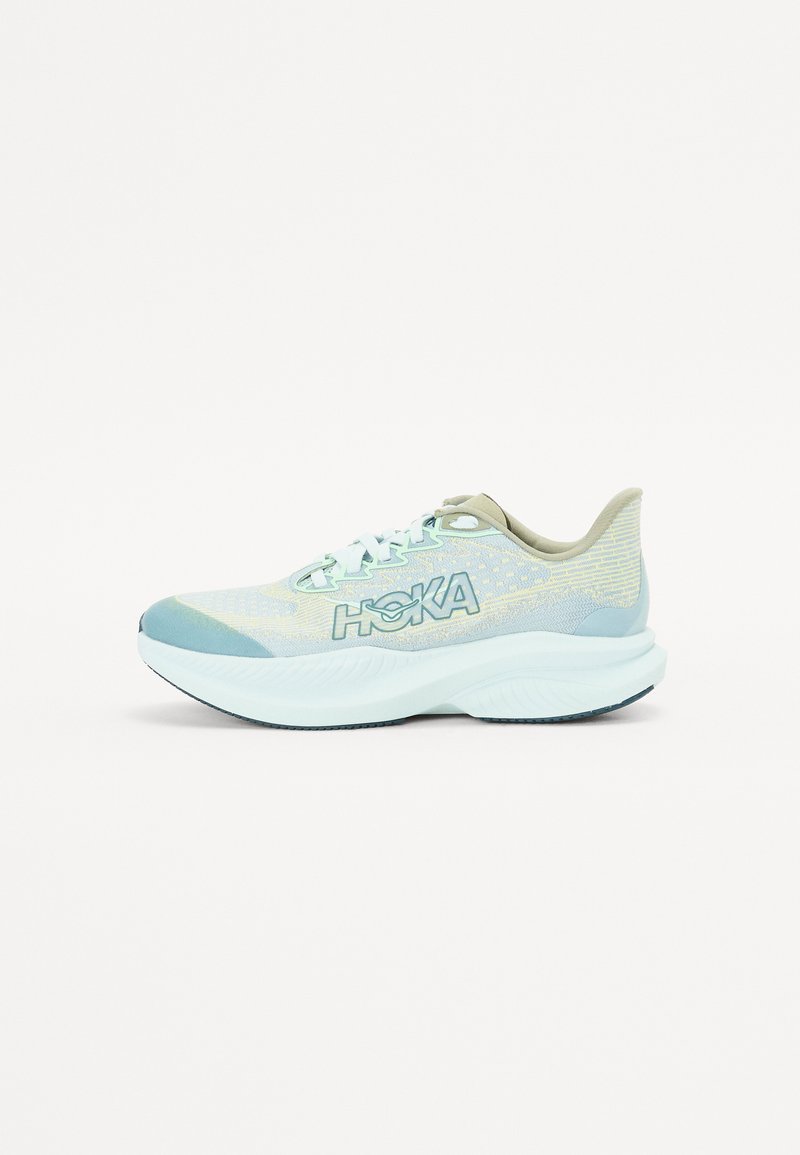 Baskets de sport bleu clair avec une tige en maille respirante, une semelle intermédiaire blanche chunky et des accents texturés. Présente le logo HOKA sur le côté.