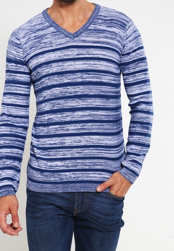 Blå och ljusblå randig långärmad v-ringad tröja med en strukturerad stickning, ribbade ärmslut och nederkant, iklädd denimjeans.