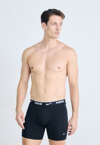 Črne bombažne bokserice z belim pasom z znamko, na katerem je logotip Nike. Gladka tekstura in prilegajoča zasnova za udobje.