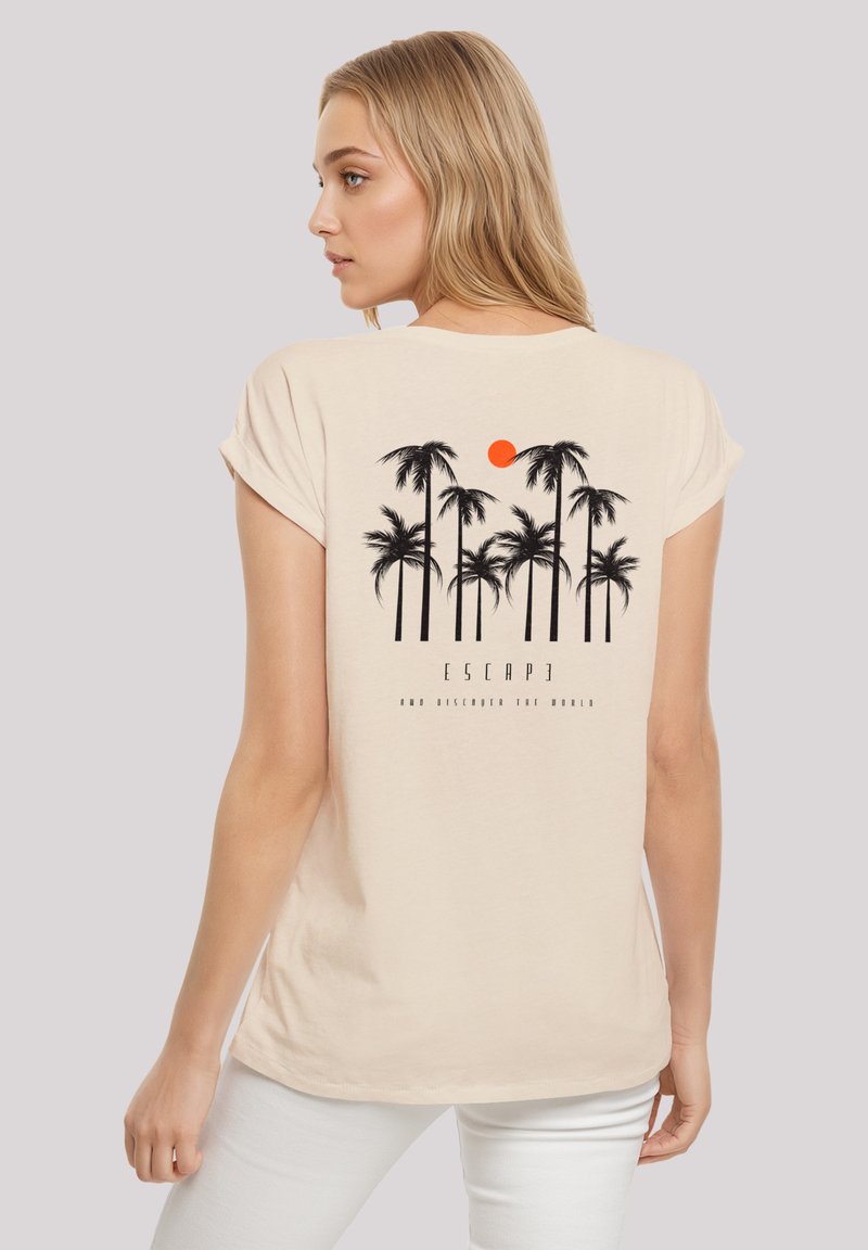 Light beige short-sleeve t-shirt featuring a black palm tree graphic and an orange sun on the back, with "ESCAPE" text underneath.