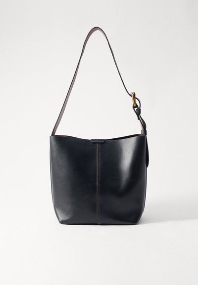 Schwarze Leder-Schultertasche mit glatter Oberfläche, ausgestattet mit einem dünnen, langen Tragegurt und einem dezenten genähten Detail in der Mitte.