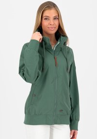 Grøn zip-up jakke med høj krave, elastiske manchetter, to sidelommer og en struktureret overflade. Har snoretræk og logo detaljer.