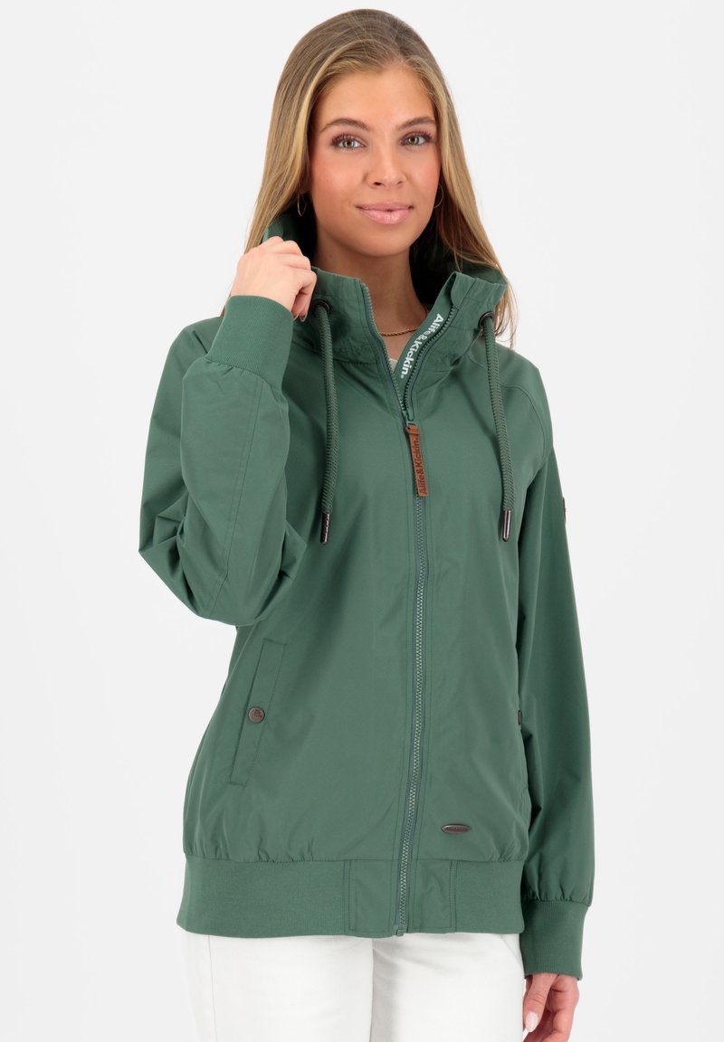Grøn zip-up jakke med høj krave, elastiske manchetter, to sidelommer og en struktureret overflade. Har snoretræk og logo detaljer.