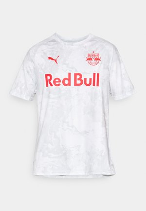 Camisa de futebol branca de manga curta com um padrão texturizado em mármore; apresenta "Red Bull" em letras vermelhas em destaque e o logótipo da Puma.