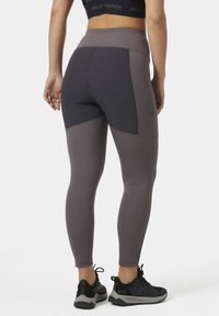 Hoge prestaties leggings in een mix van donkergrijs en gedempt mauve, met een gladde textuur, een taps toegespitste pasvorm en contrasterende paneeldetails.
