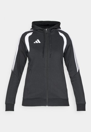 Sweat à capuche zippé noir en tissu texturé, avec des bandes blanches sur les côtés, une capuche à cordon et un logo Adidas sur le côté gauche de la poitrine.