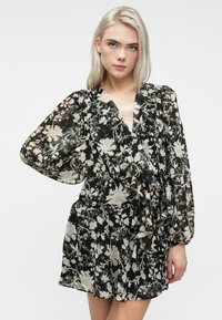 Abito nero con stampa floreale, realizzato in tessuto trasparente, caratterizzato da lunghe maniche a sbuffo, scollatura a V profonda e dettagli di orlo arricciato.