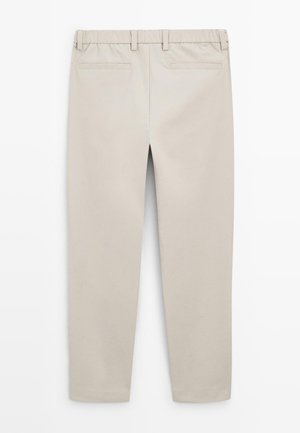 Pantaloni beige a gamba dritta con vita elasticizzata e due tasche a filetto posteriori, mostrati da dietro su sfondo bianco.