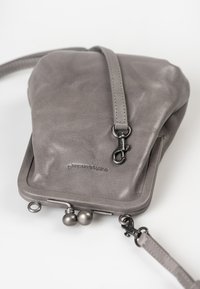 Borsa a tracolla in pelle grigia con una texture morbida, dettagli in metallo, una chiusura sicura e una silhouette curvata.