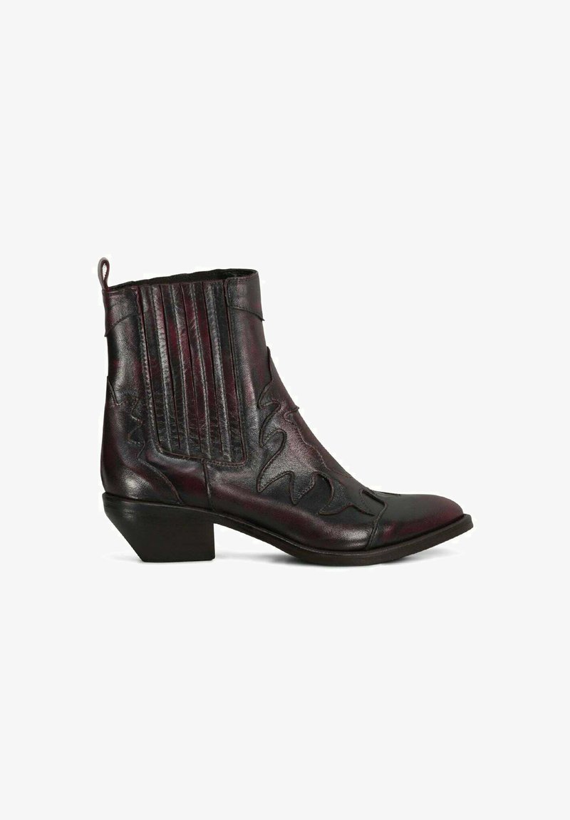 Stivale cowboy alla caviglia in pelle nera con cuciture decorative, pannelli laterali elasticizzati, linguetta e tacco basso impilato.